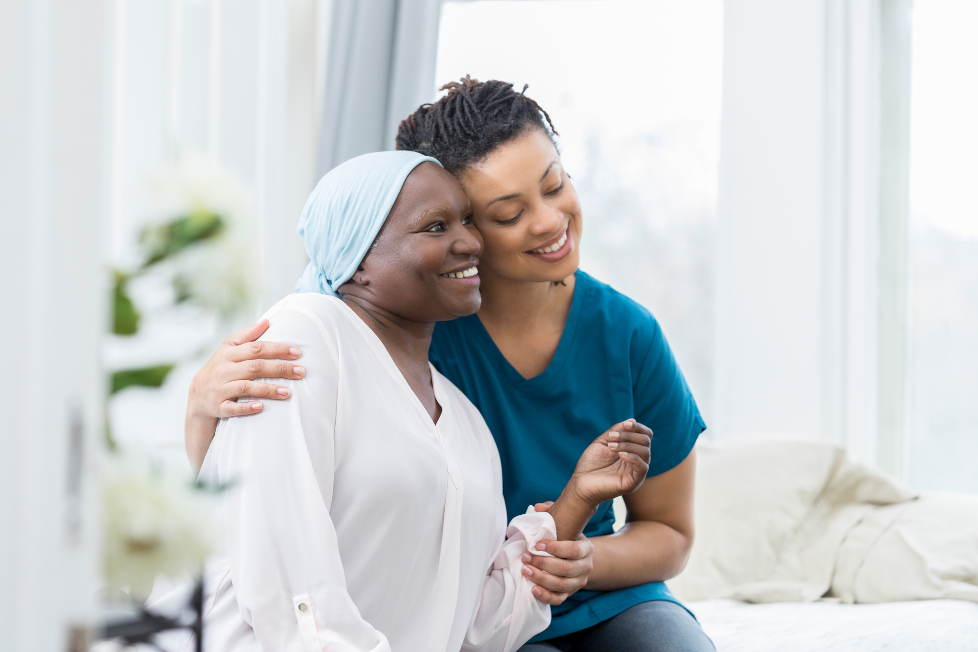 Caring nurse comforts elderly female patient